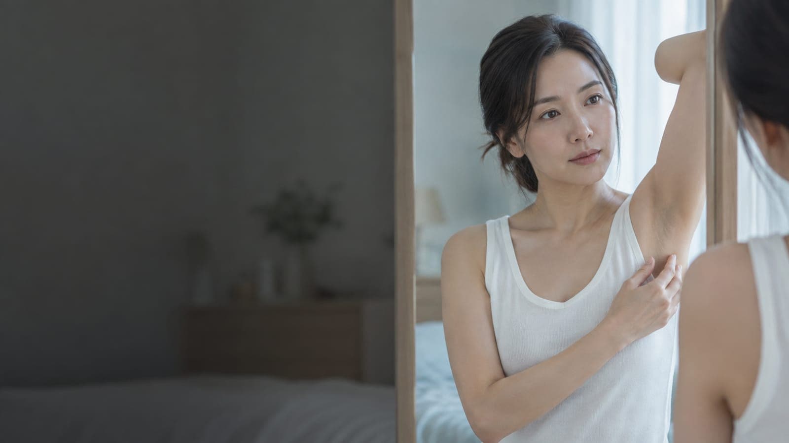 거울 앞에서 겨드랑이를 살펴보는 한국인 여성